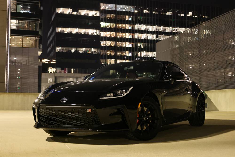 Black Toyota GR86 parked on a rooftop deck with the Austin skyline behind