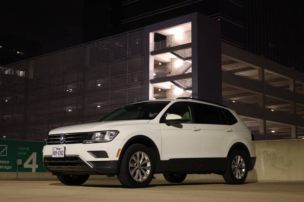 White Volkswagen Tiguan parked on a rooftop deck at night