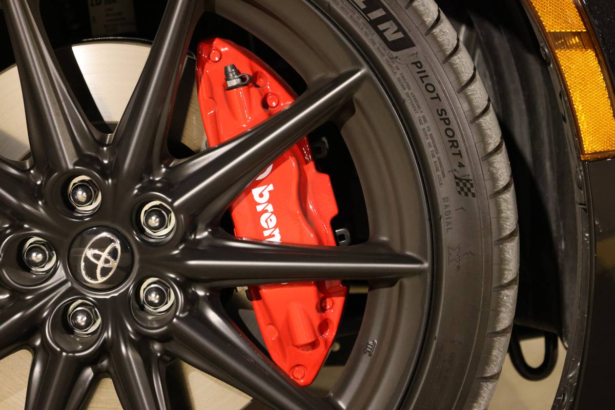 Red Brembo brake caliper behind a black alloy wheel